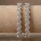Silver-plated bangle featuring two zirconia-encrusted clover motifs on a jewelry display.