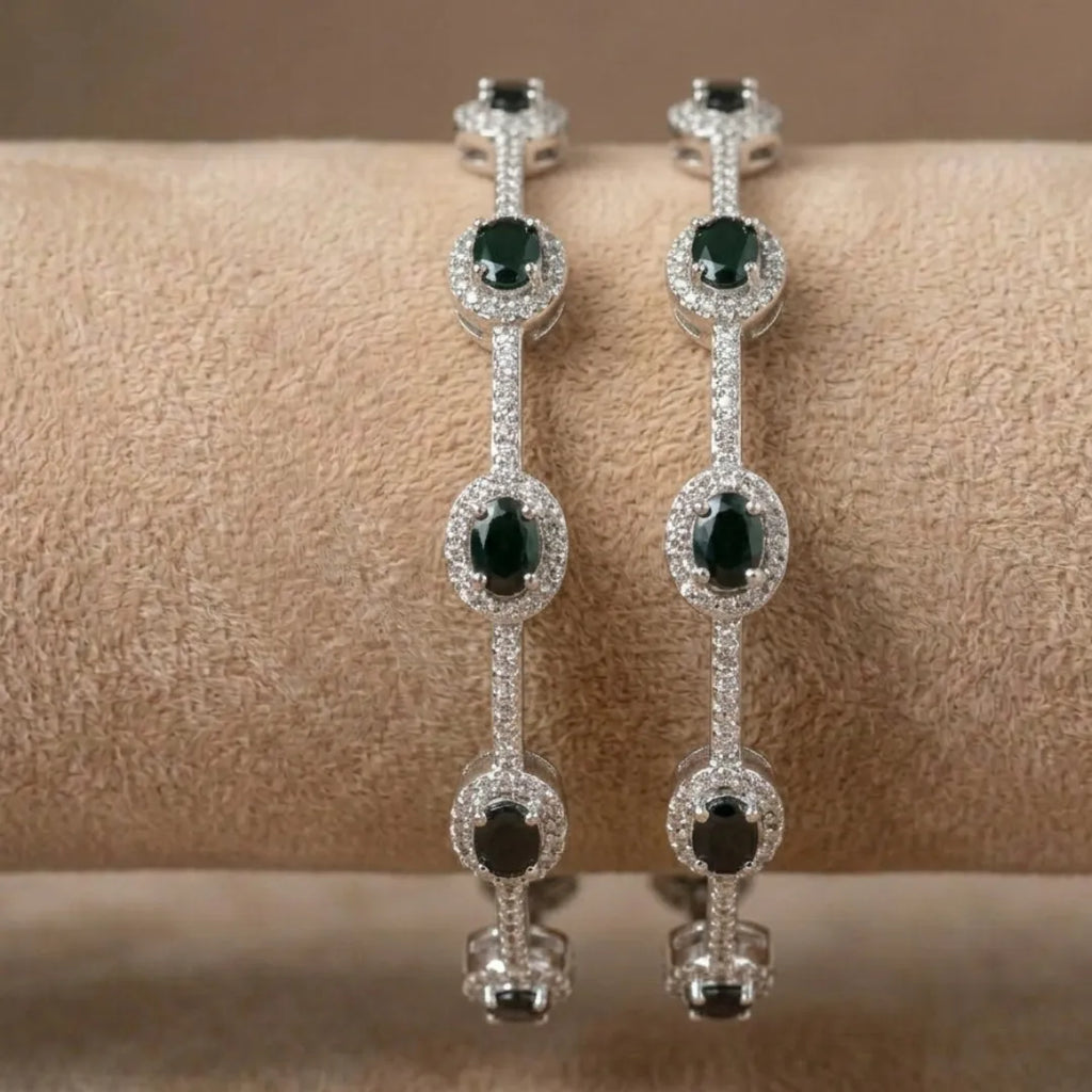 Silver-plated eternity bangle with pavé-set zirconia stones displayed on a black surface.