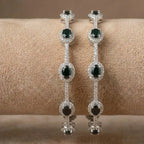 Silver-plated eternity bangle with pavé-set zirconia stones displayed on a black surface.