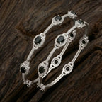 Silver-plated eternity bangle with pavé-set zirconia stones displayed on a black surface.