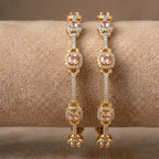 Luxury gold-toned bangle with earthy bronze stones and intricate petal motifs.