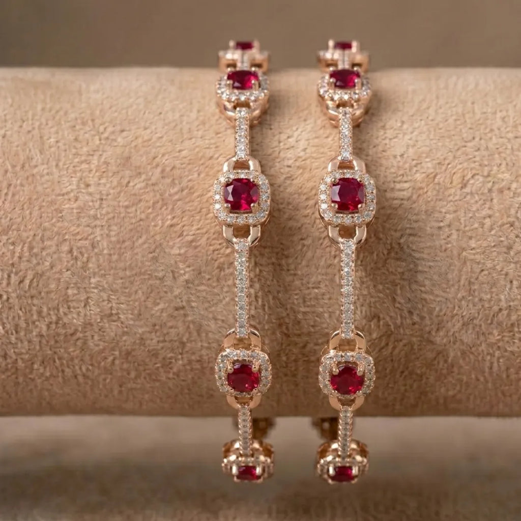 Gold-plated eternity bangle with red center stones and white floral zirconia design.