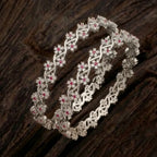 Silver-plated bangle featuring two zirconia-encrusted clover motifs on a jewelry display.