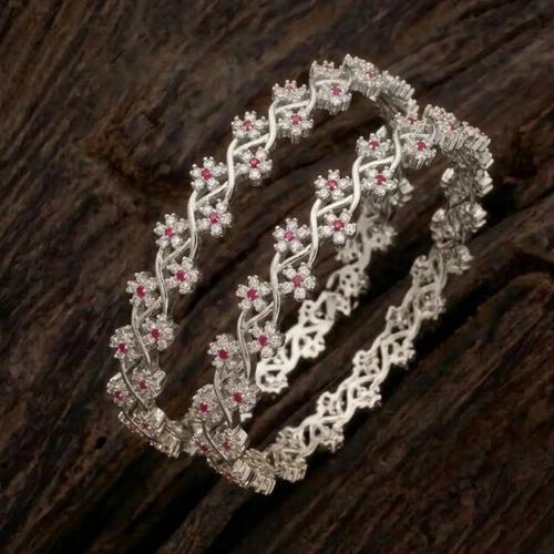 Silver-plated bangle featuring two zirconia-encrusted clover motifs on a jewelry display.
