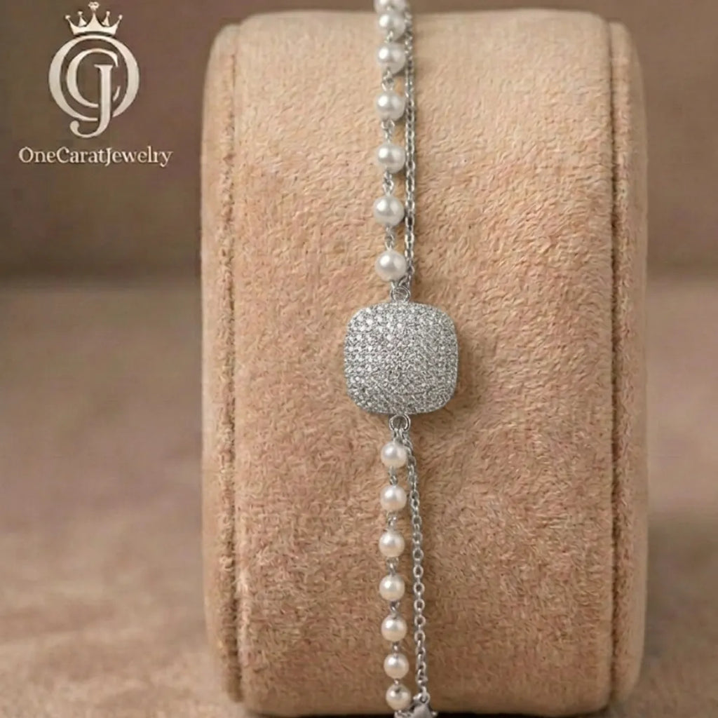 Silver-plated cushion zirconia bracelet with double-layer pearl and chain design on a jewelry display.