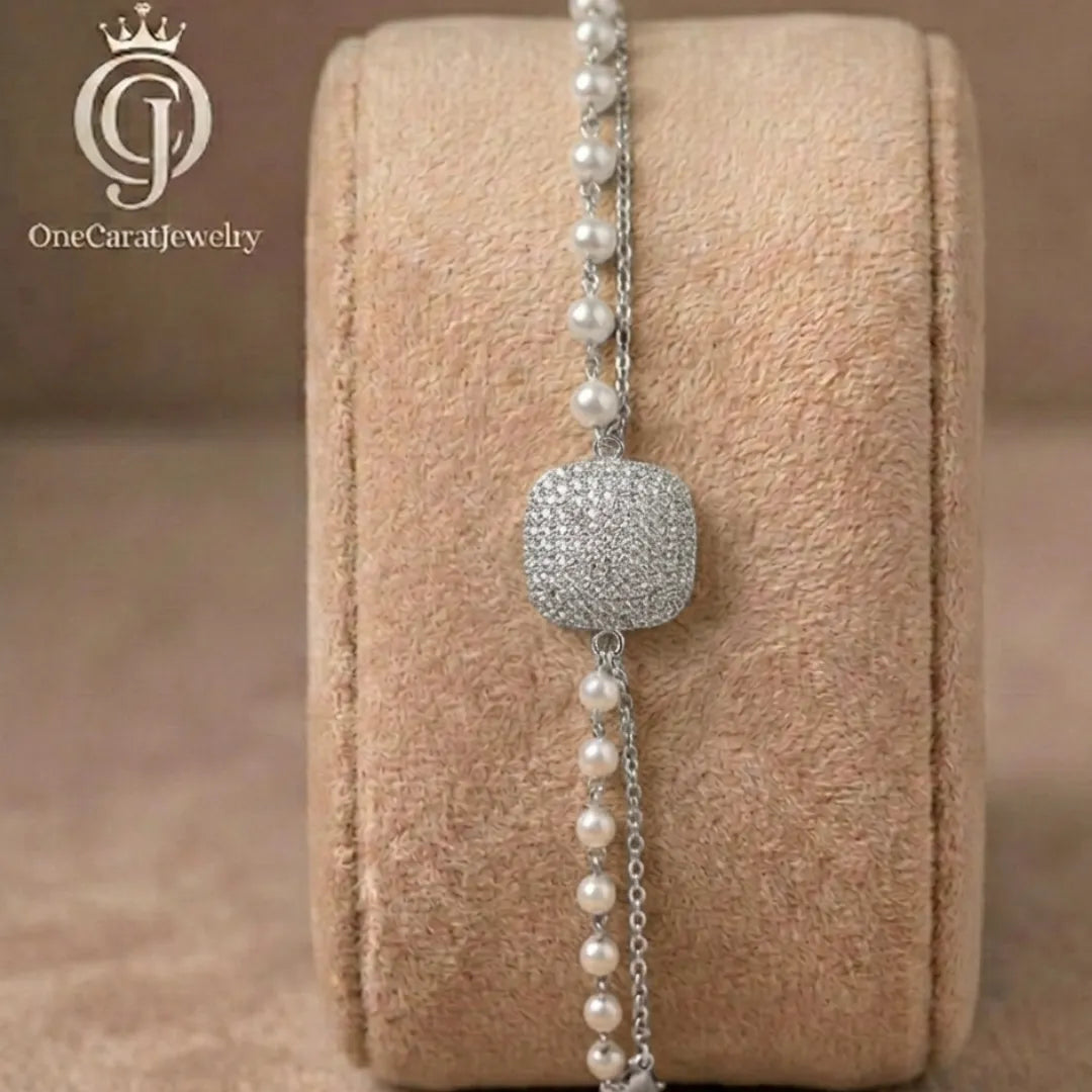 Silver-plated cushion zirconia bracelet with double-layer pearl and chain design on a jewelry display.