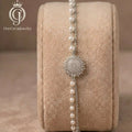 Silver-plated sunburst and pearl bracelet displayed on a velvet jewelry roll.
