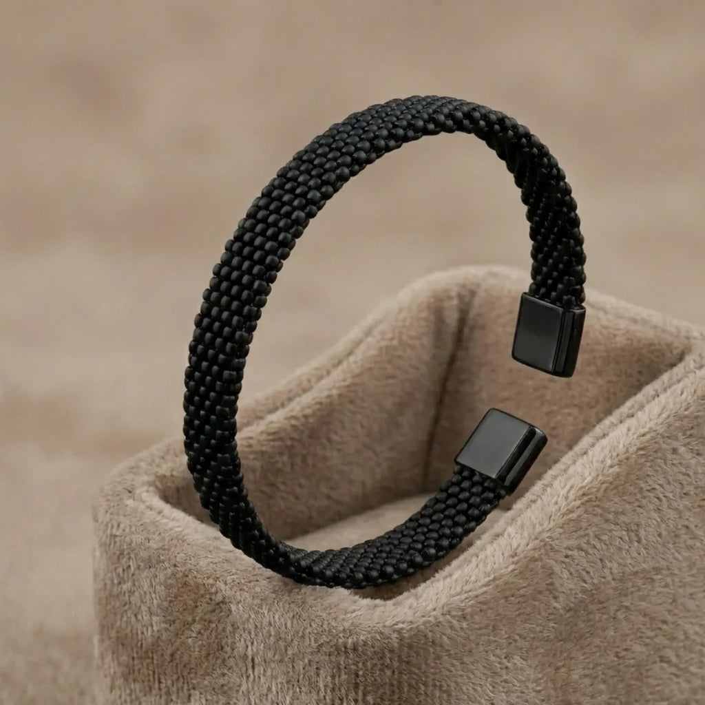 Silver-toned stainless steel cuff bracelet with three parallel grooved lines on a professional stand.