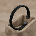 Silver-toned stainless steel cuff bracelet with three parallel grooved lines on a professional stand.