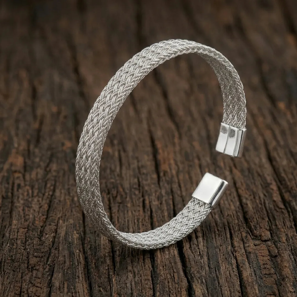 High-polish silver V-shape geometric cuff bracelet on a minimalist display stand.