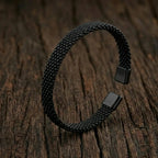 Silver-toned stainless steel cuff bracelet with three parallel grooved lines on a professional stand.