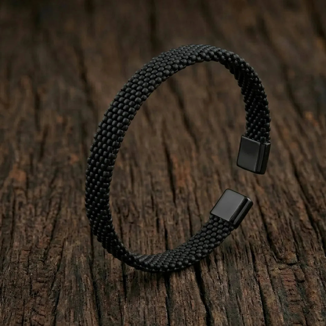 Silver-toned stainless steel cuff bracelet with three parallel grooved lines on a professional stand.