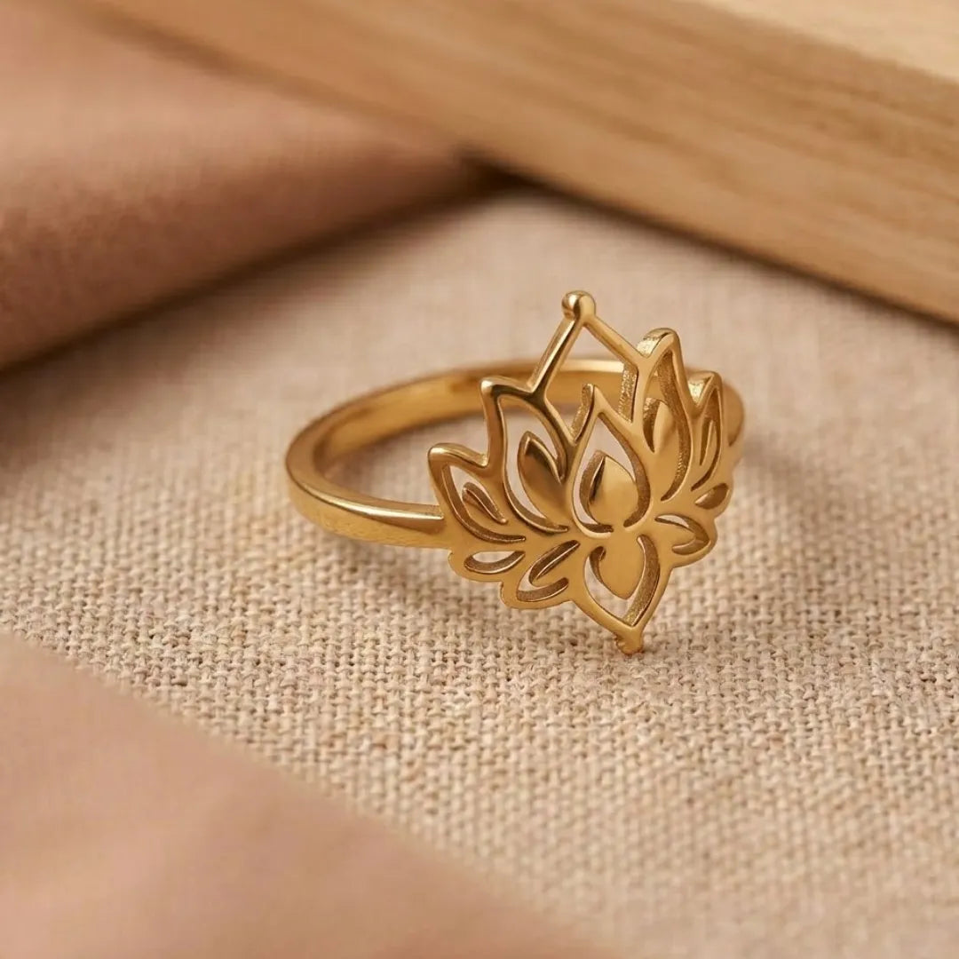 Gold lotus flower ring on a beige fabric background