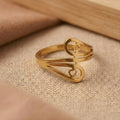 Gold ring with intricate design on a beige fabric background