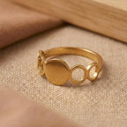Gold ring with circular design on a beige fabric background