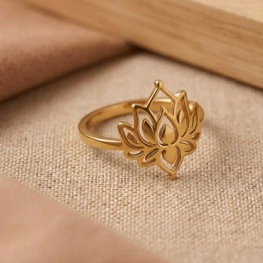Gold lotus flower ring on a beige fabric background