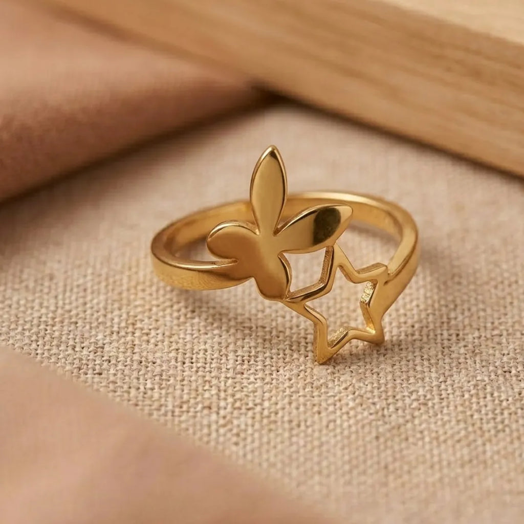Gold ring with butterfly design on a beige fabric background