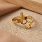 Gold ring with butterfly design on a beige fabric background