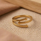 Gold ring with a unique design on a beige fabric background