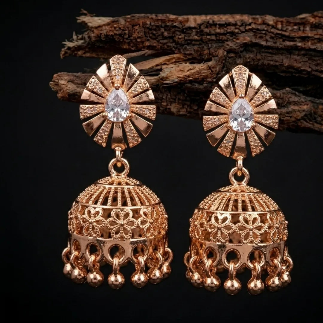 Gold earrings with intricate designs on a dark background