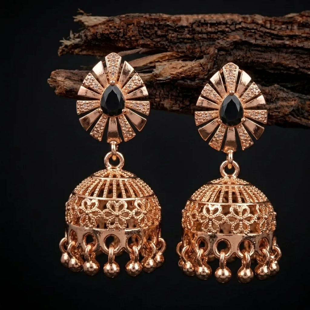 Gold earrings with black gemstones on a dark background