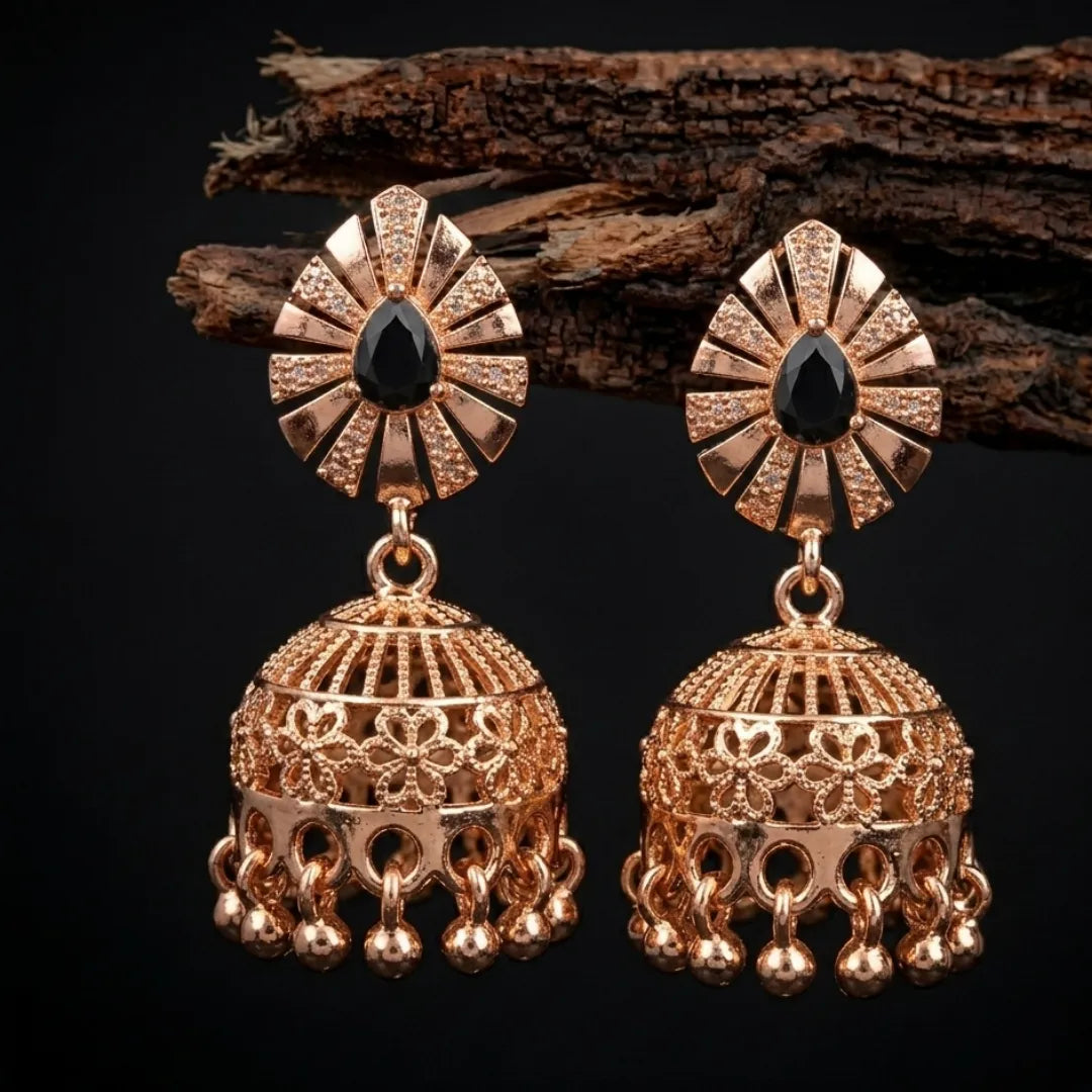 Gold earrings with black gemstones on a dark background