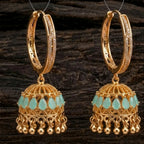 Gold hoop earrings with turquoise drops on a wooden background