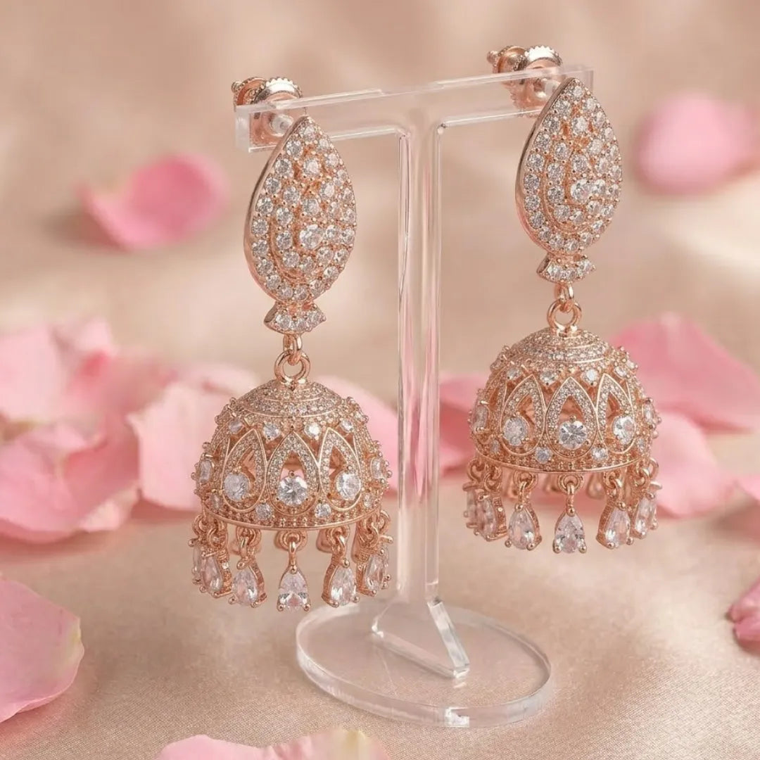 Luxury antique gold-plated jhumka earrings featuring elegant white pearl droplets on a professional display.