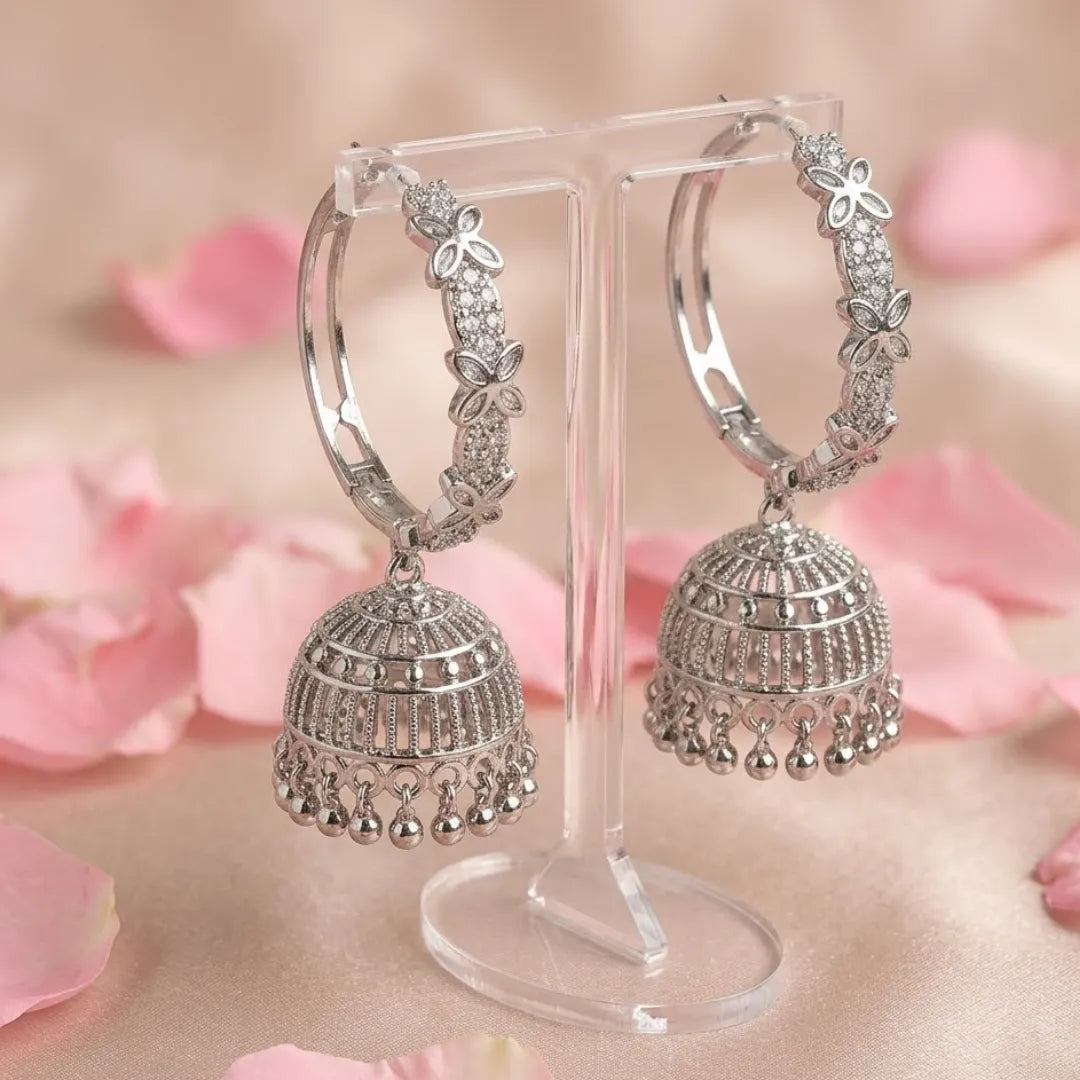 Silver hoop earrings on a stand with pink floral background