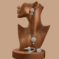 Jewelry set with necklace, earrings, and ring on a brown mannequin bust against a beige background
