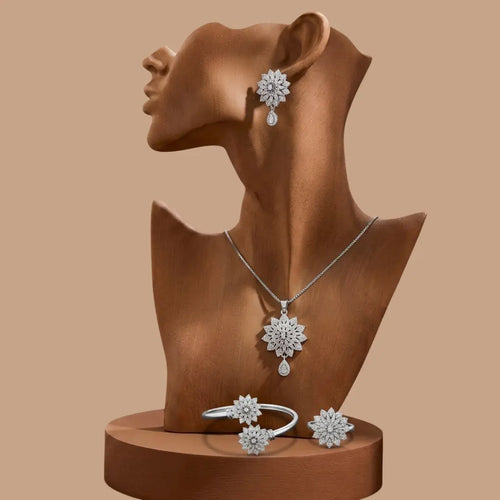 Jewelry set with necklace, earrings, and ring on a brown mannequin bust against a beige background