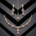Rose Gold necklace set with pink stones and maang tikka on a black geometric background