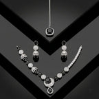 Luxury black and silver zirconia necklace set with earrings and pendant on a black geometric background.