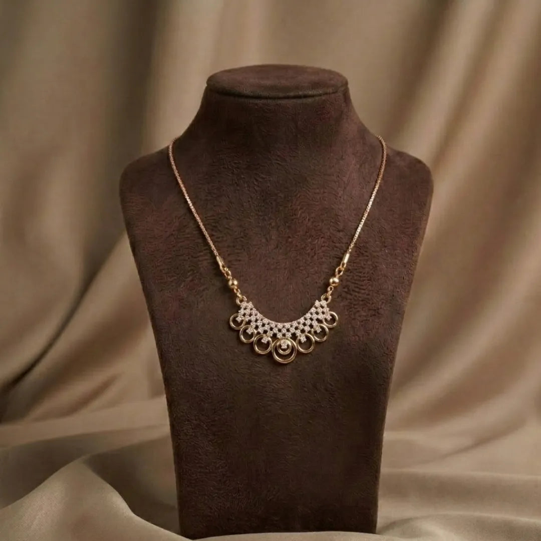 Gold necklace on a brown mannequin bust with a brown fabric background