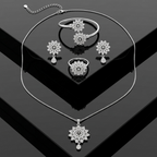Silver floral pendant set with bangle, ring, and earrings on a sleek black background
