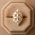 Decorative ring with white stones on a beige cushioned stand