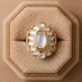 Bold golden leaf statement ring worn by a model, styled with a formal luxury outfit.