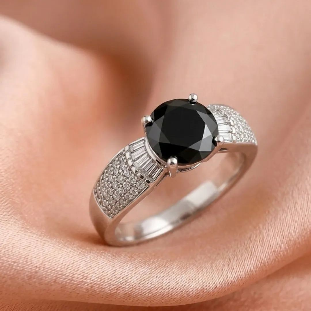 Silver ring with a black gemstone on a skin background