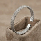 High-polish silver V-shape geometric cuff bracelet on a minimalist display stand.