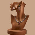 Multi-color Navratna style necklace and earrings set with rose-gold finish on a mannequin.